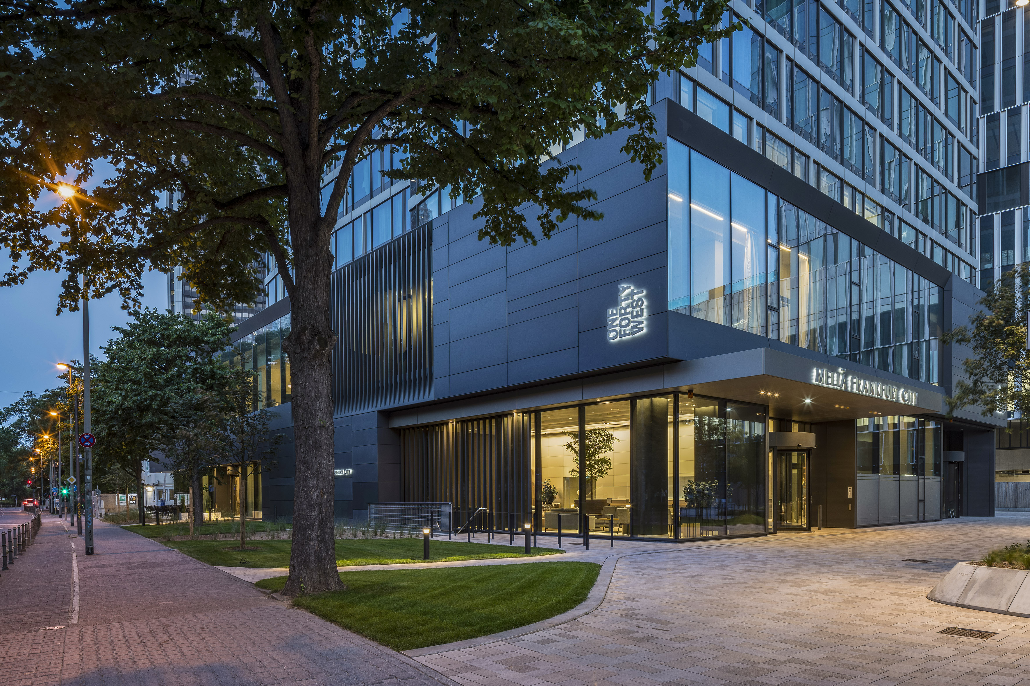 a building with glass windows and trees