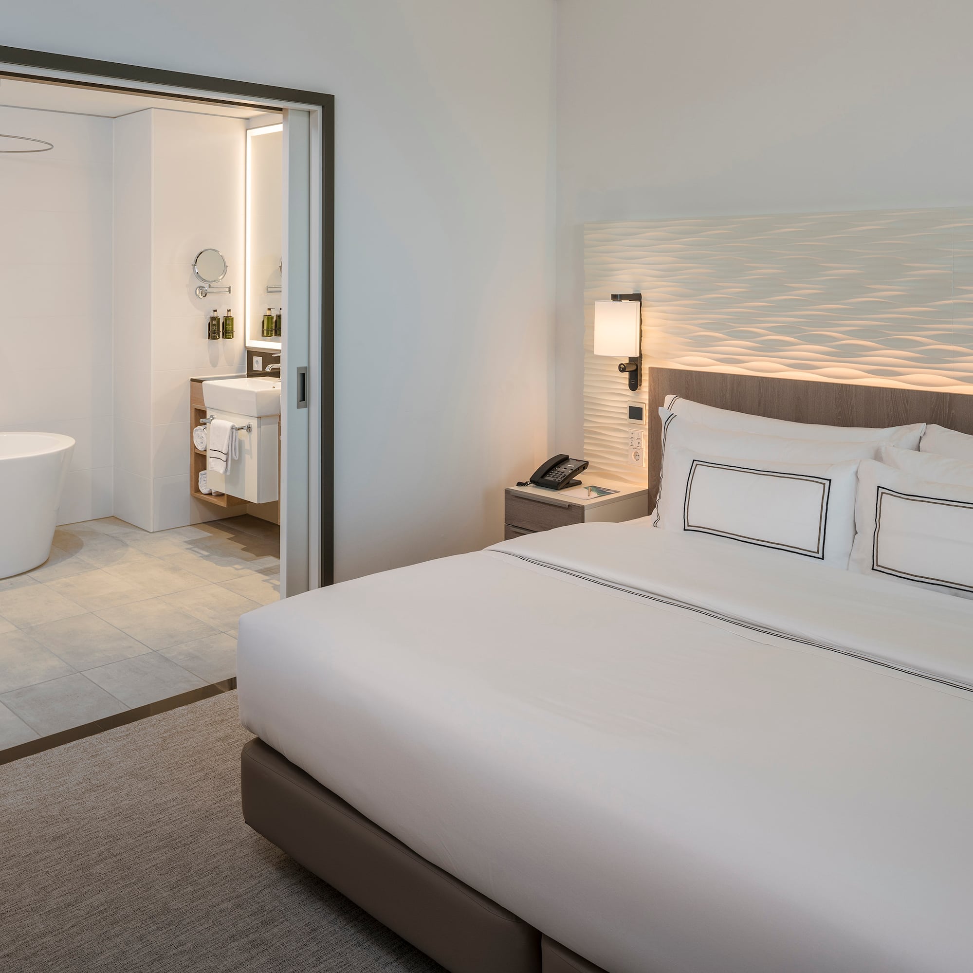 a bedroom with a bathtub and a bed