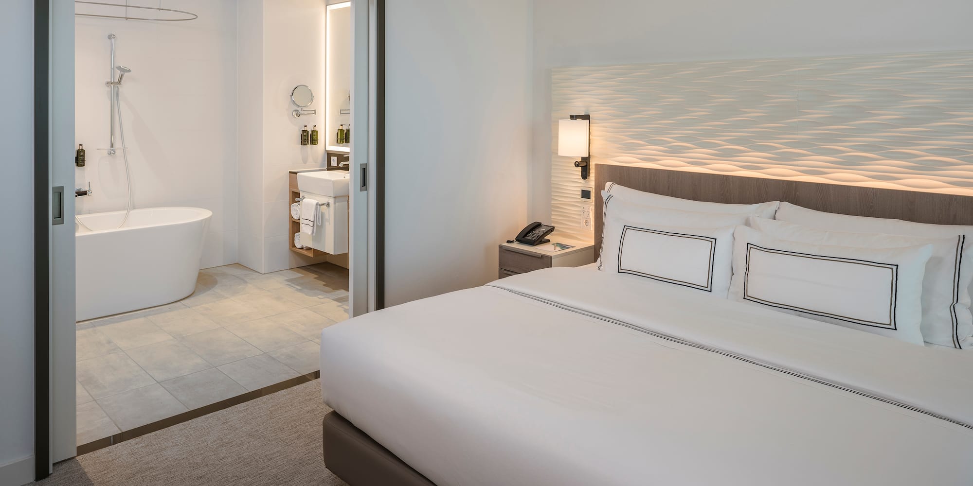 a bedroom with a bathtub and a bed