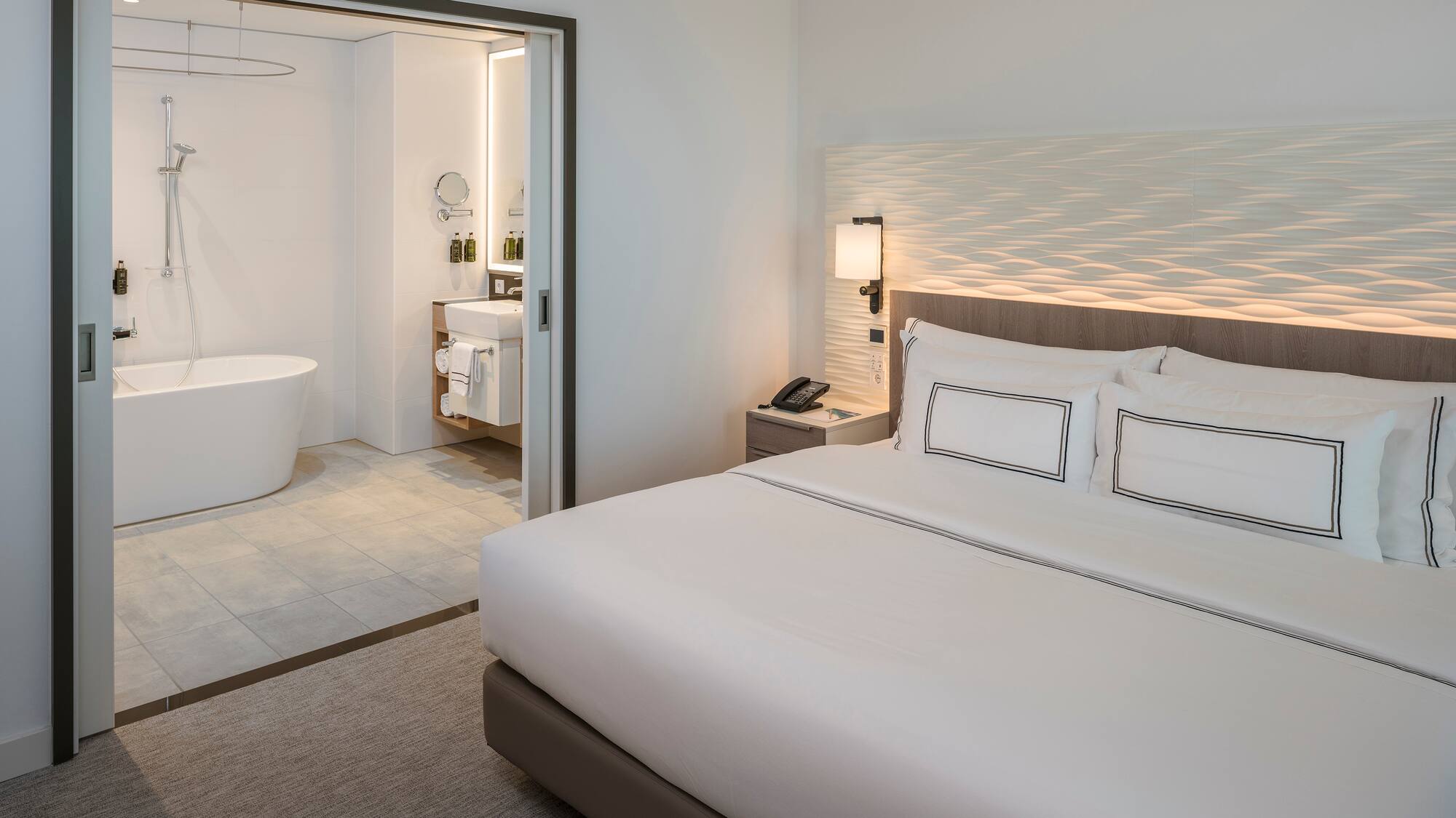 a bedroom with a bathtub and a bed