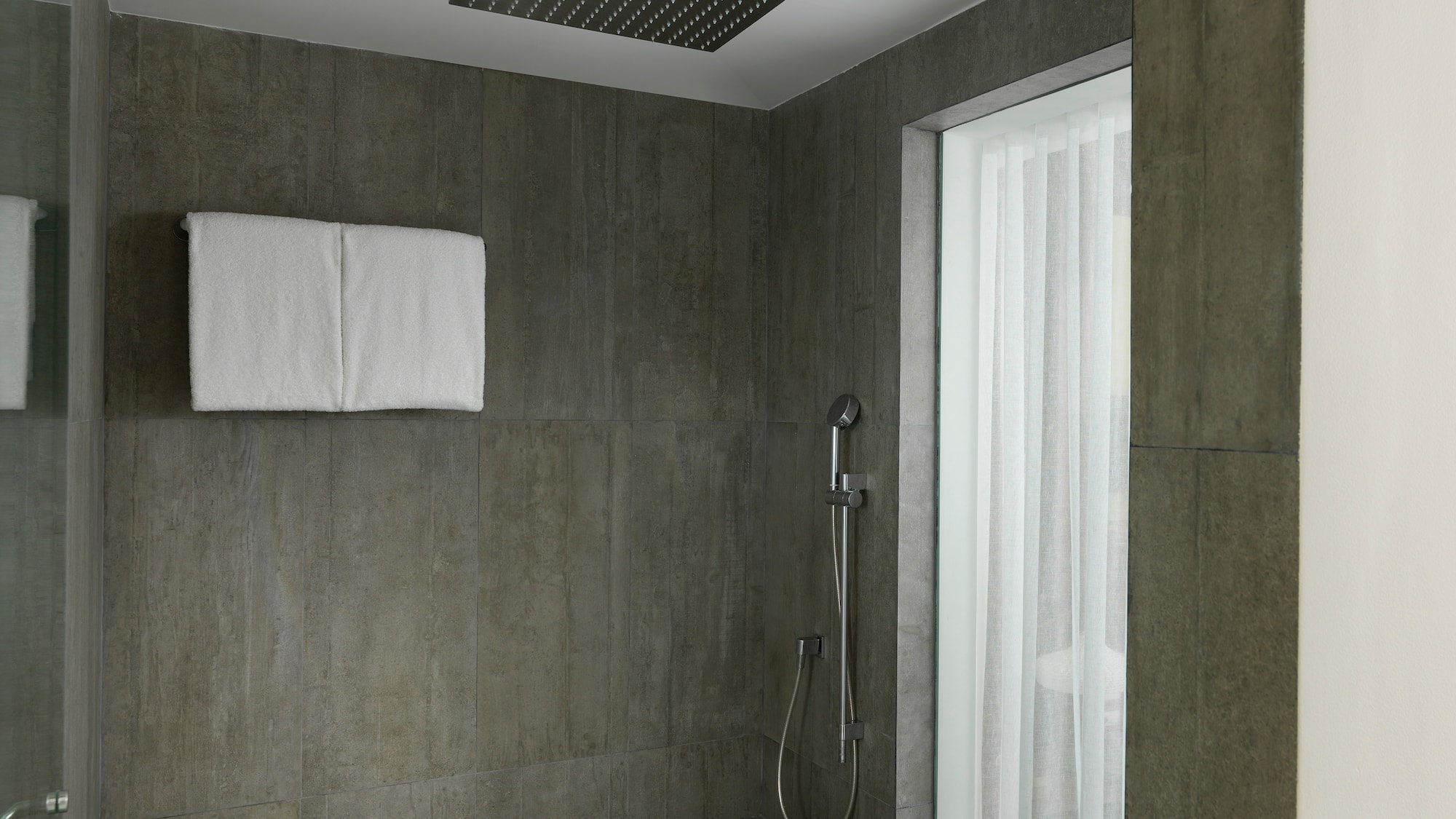 a shower with a shower head and a shower seat