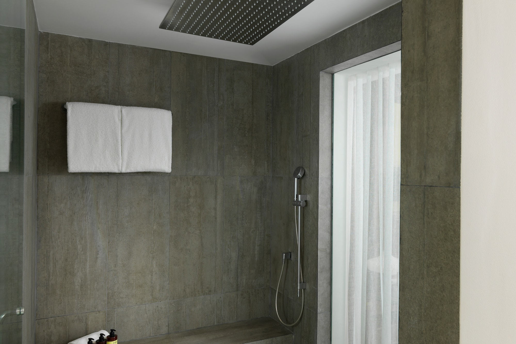 a shower with a shower head and a shower seat