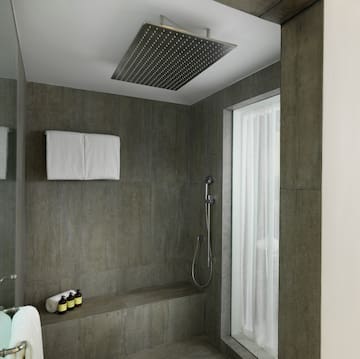 a shower with a shower head and a shower seat
