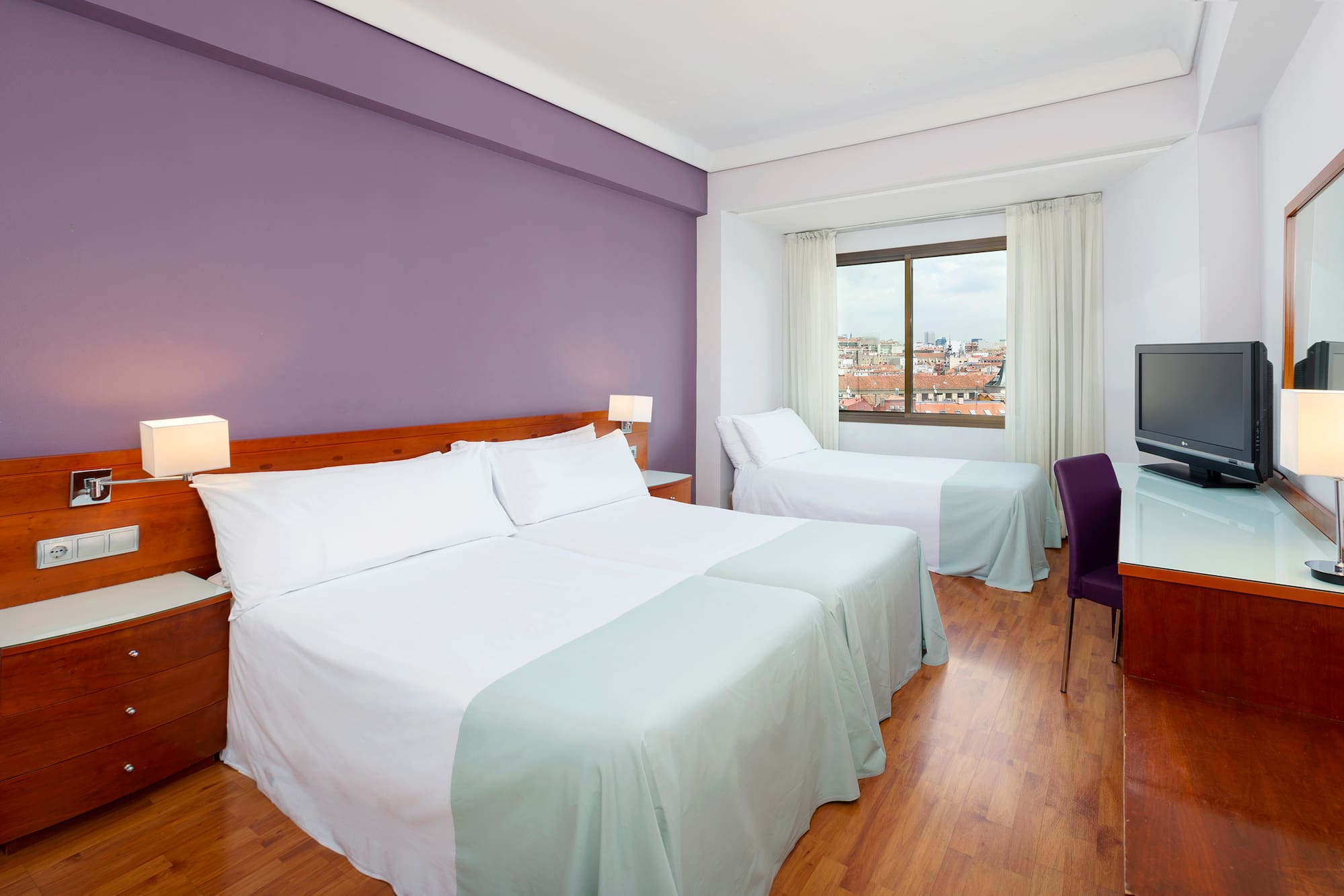 a room with two beds and a purple wall