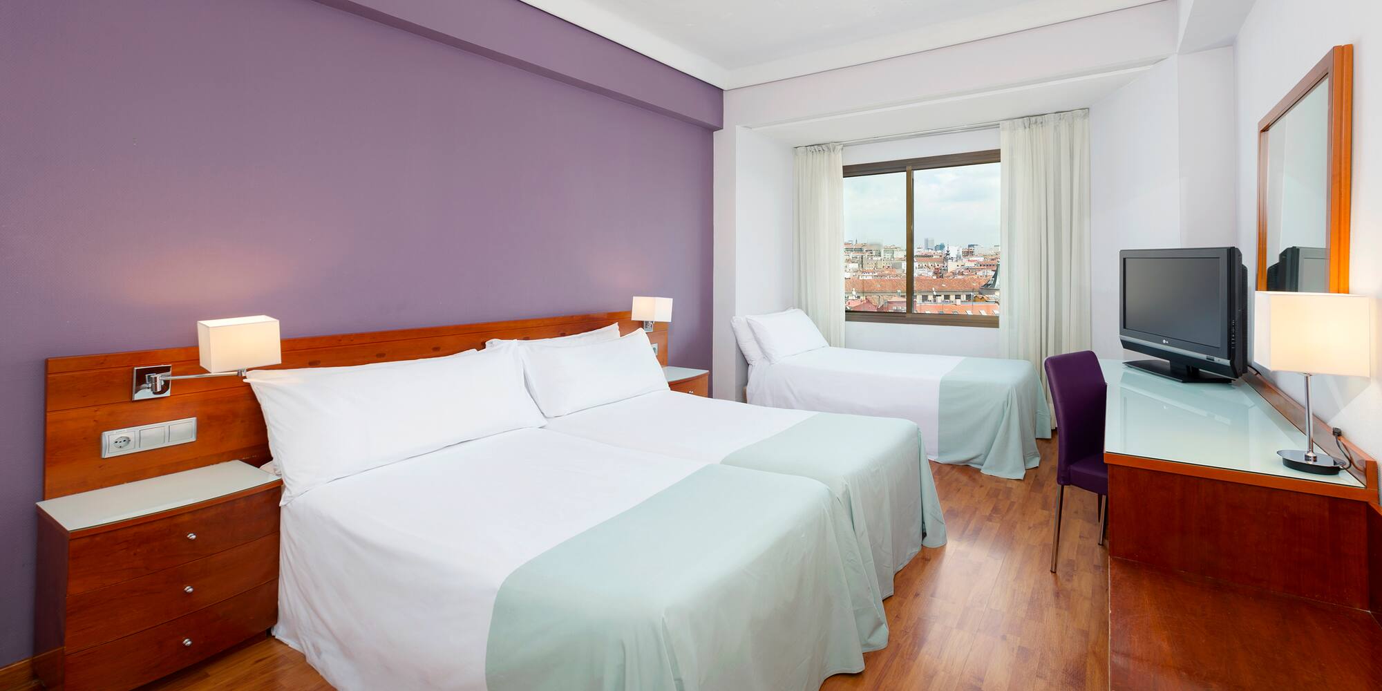 a room with two beds and a purple wall