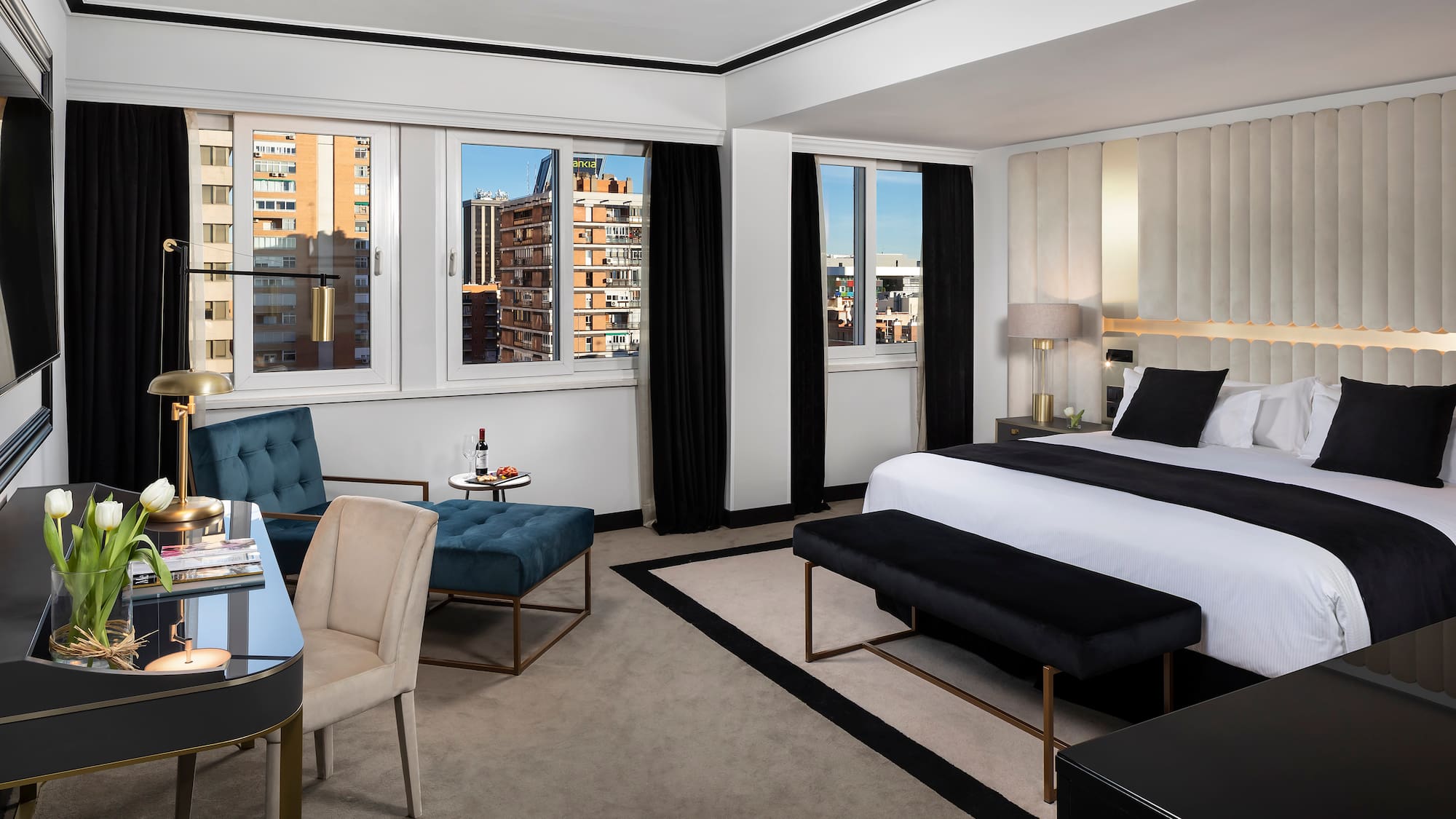 a room with a bed and chairs