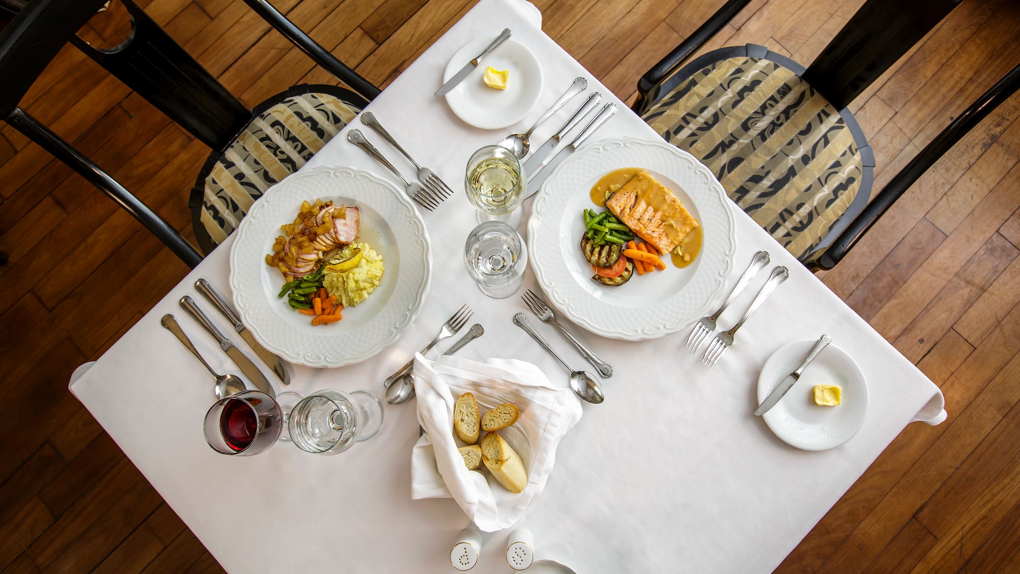 a table with plates of food and glasses