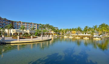 a body of water with a building and palm trees