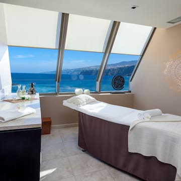 a massage table in a room with a view of the ocean