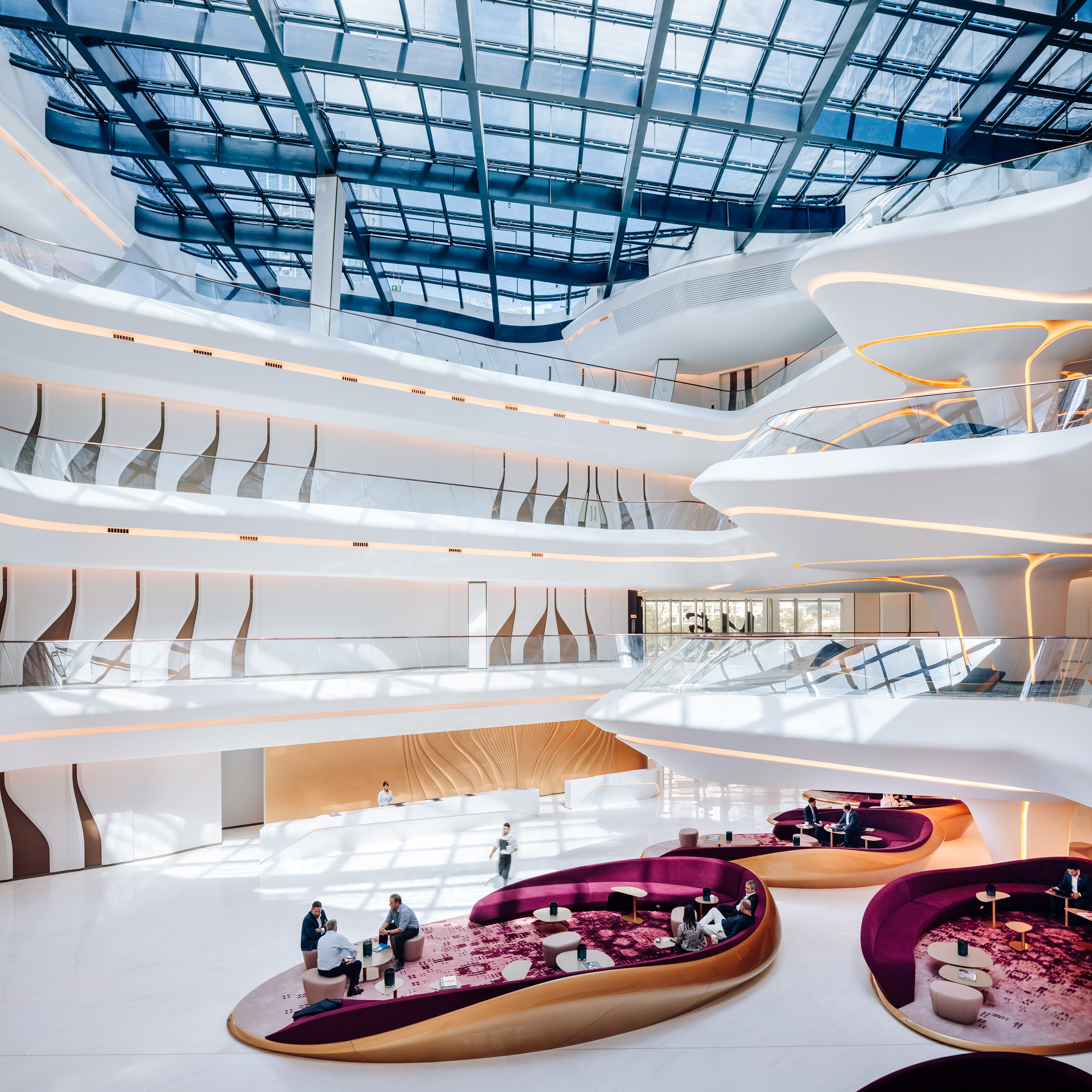Luxury modern lobby, curved white architecture, glass skylight, purple lounge.