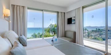 a room with a large bed and a view of the ocean