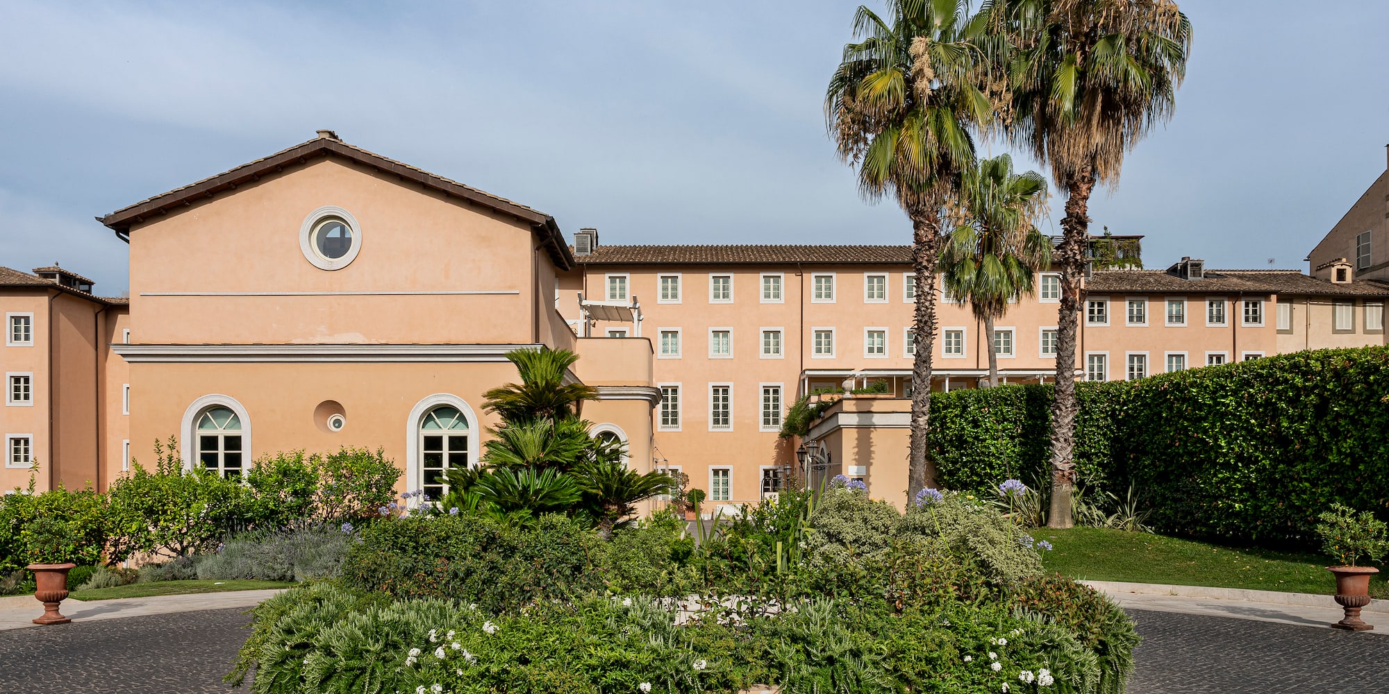 a building with palm trees and a garden