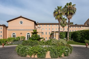 a building with palm trees and a garden