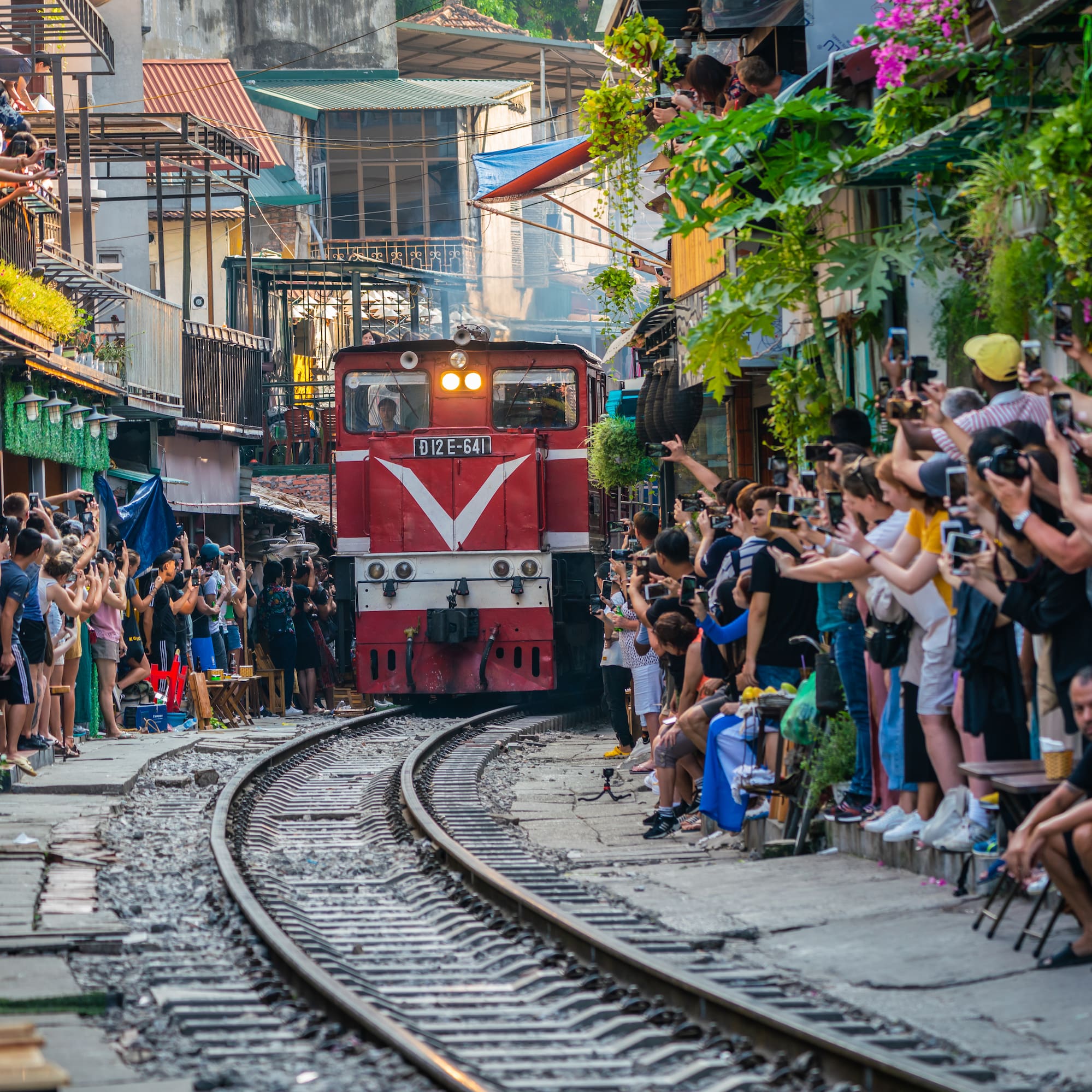 a train going down the tracks with people watching