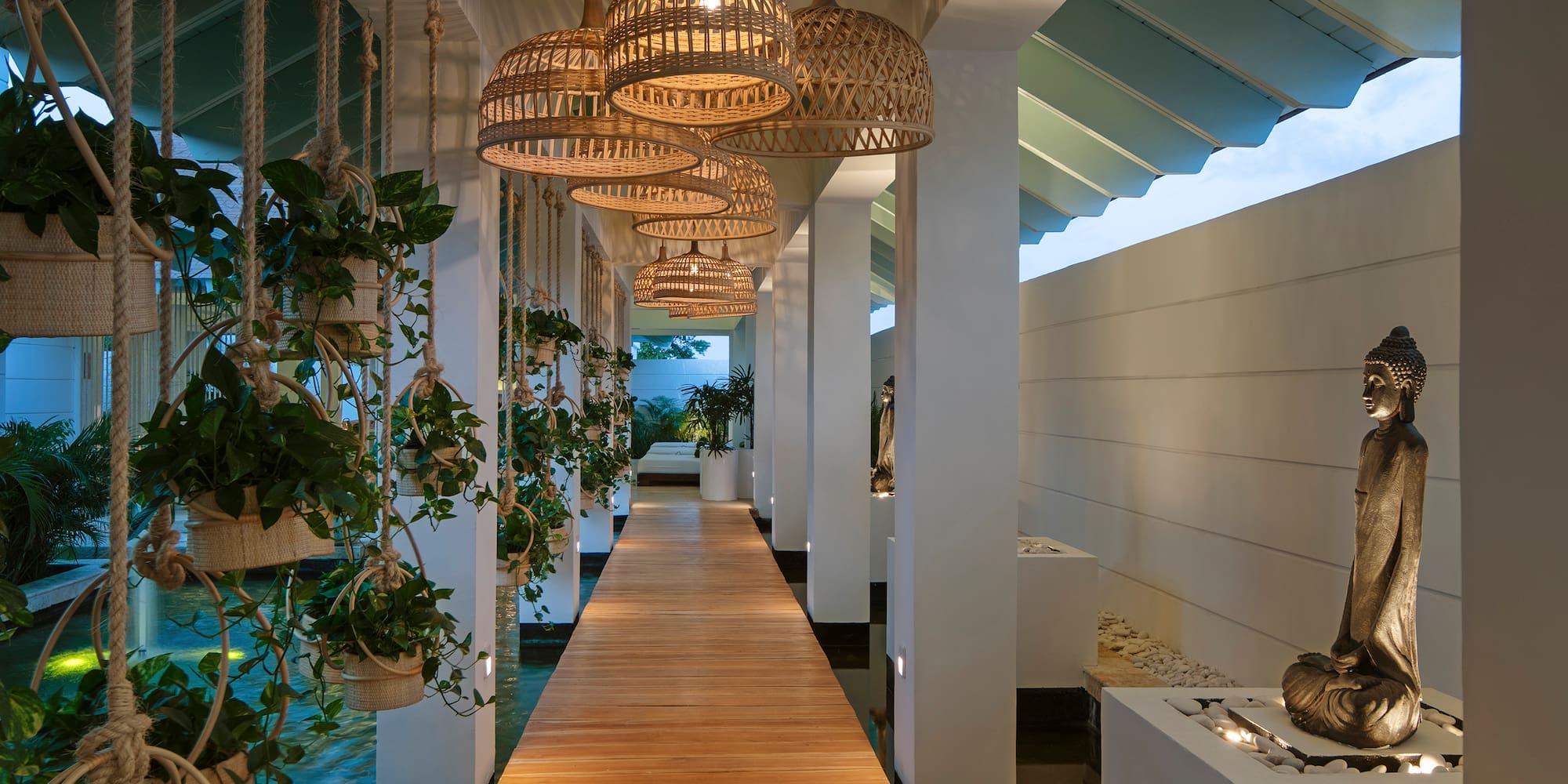 a walkway with baskets and plants from ceiling