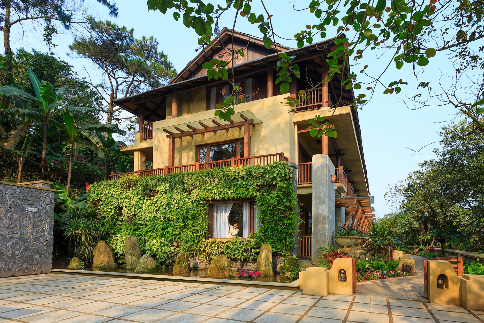 a house with a green wall and trees