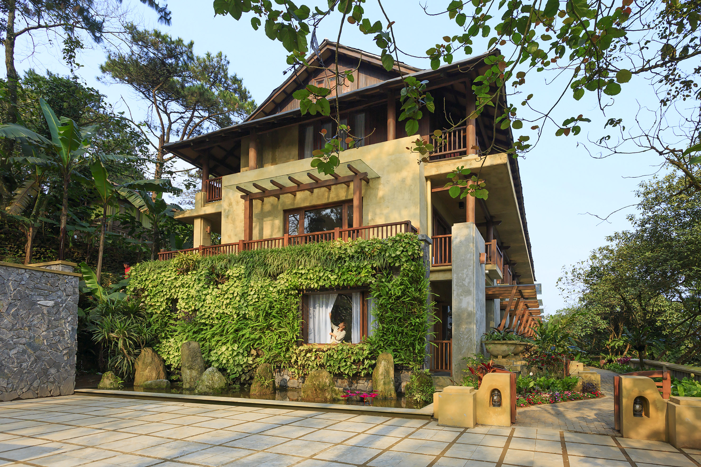 a house with a green wall and trees