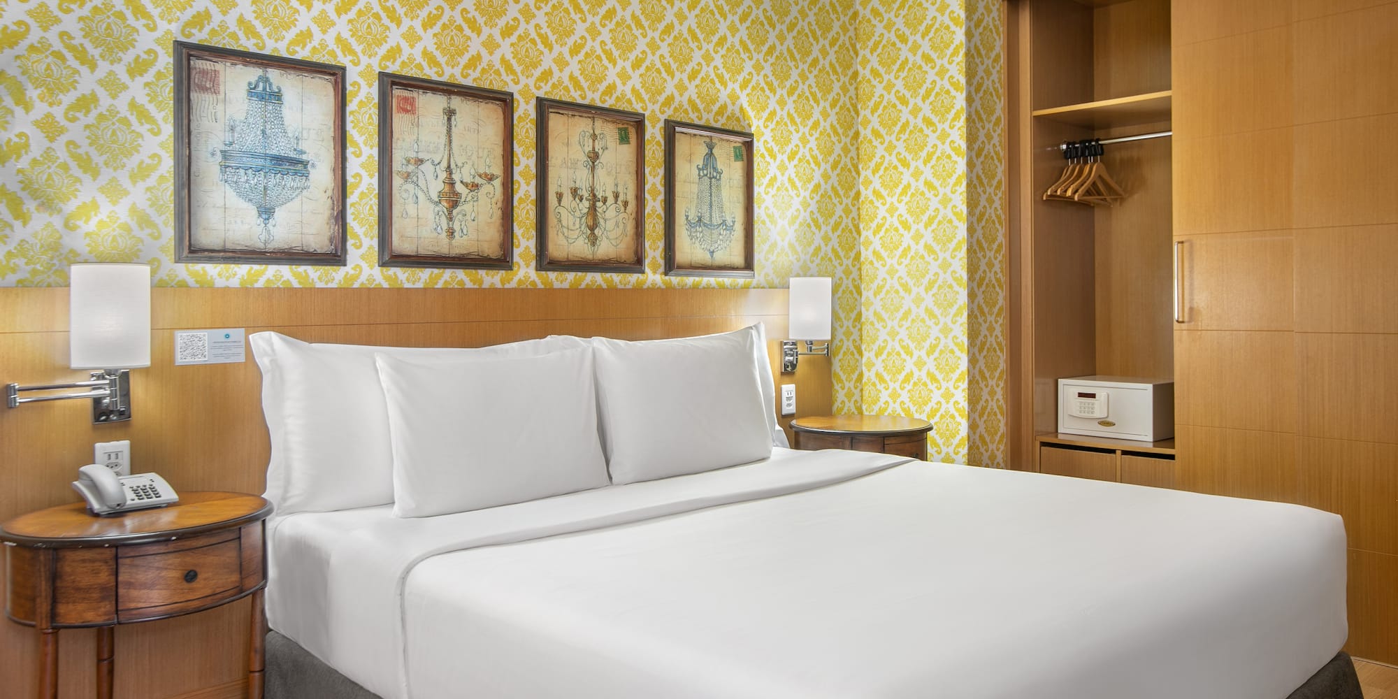 a bed with white sheets and a yellow wallpaper