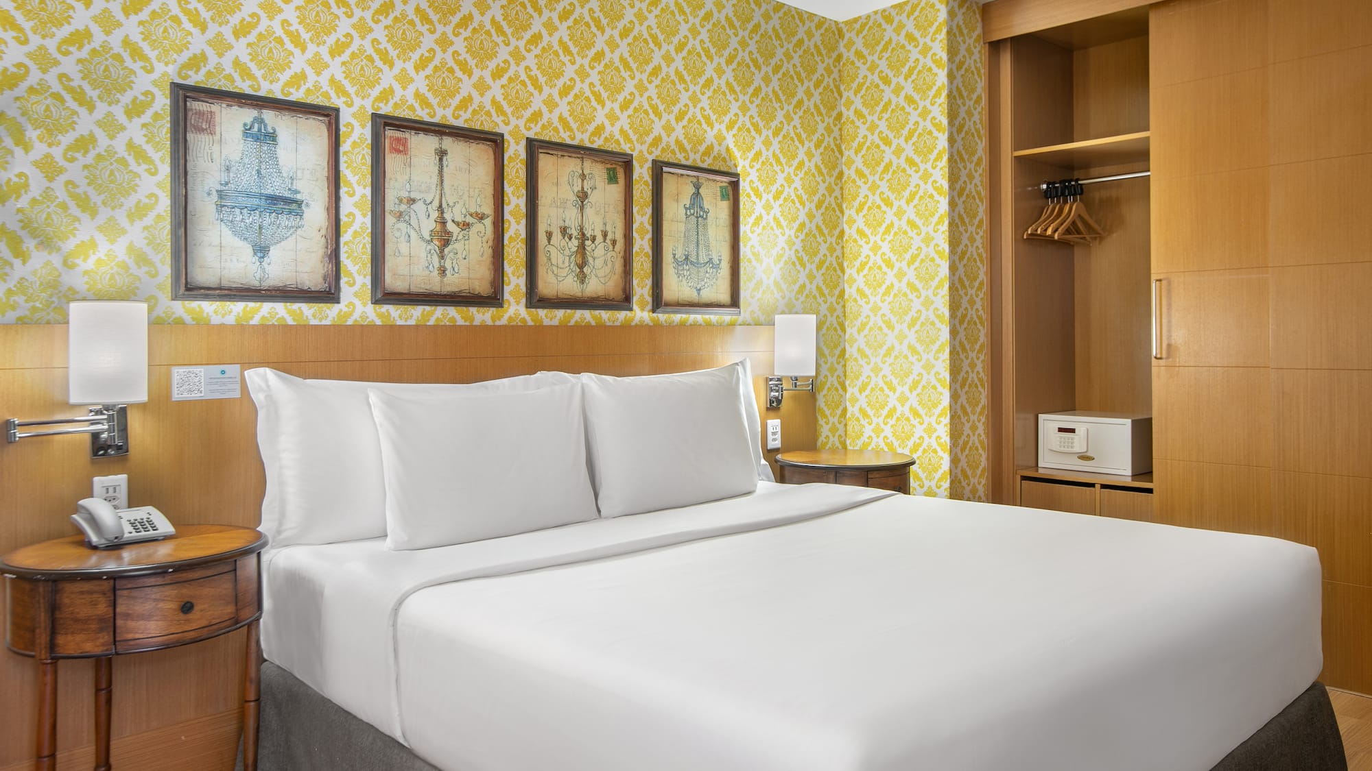 a bed with white sheets and a yellow wallpaper