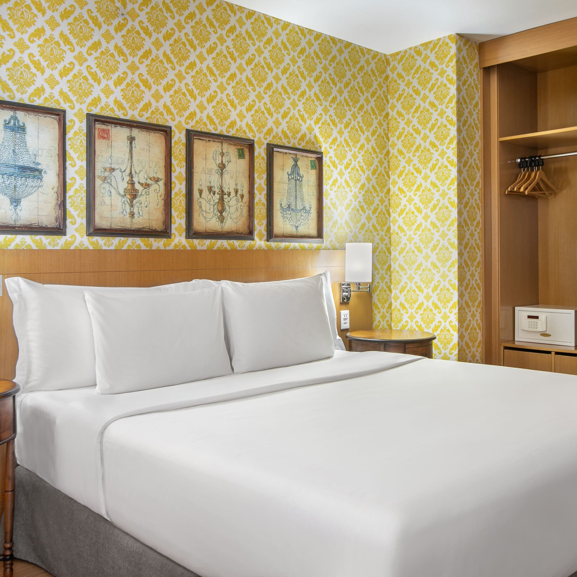 a bed with white sheets and a yellow wallpaper