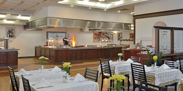 a restaurant with a chef cooking in the kitchen