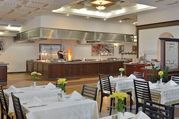 a restaurant with a chef cooking in the kitchen