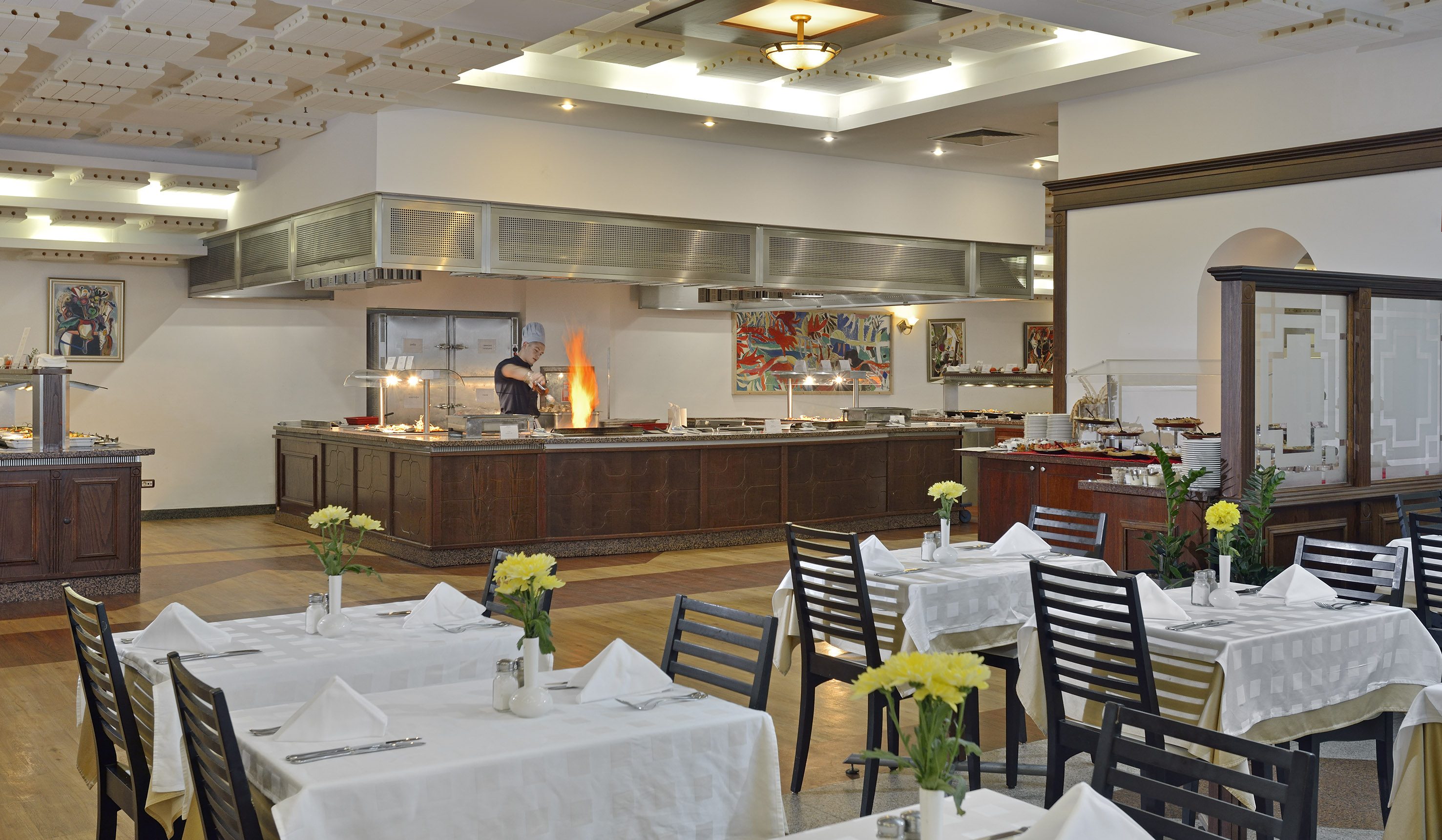 a restaurant with a chef cooking in the kitchen