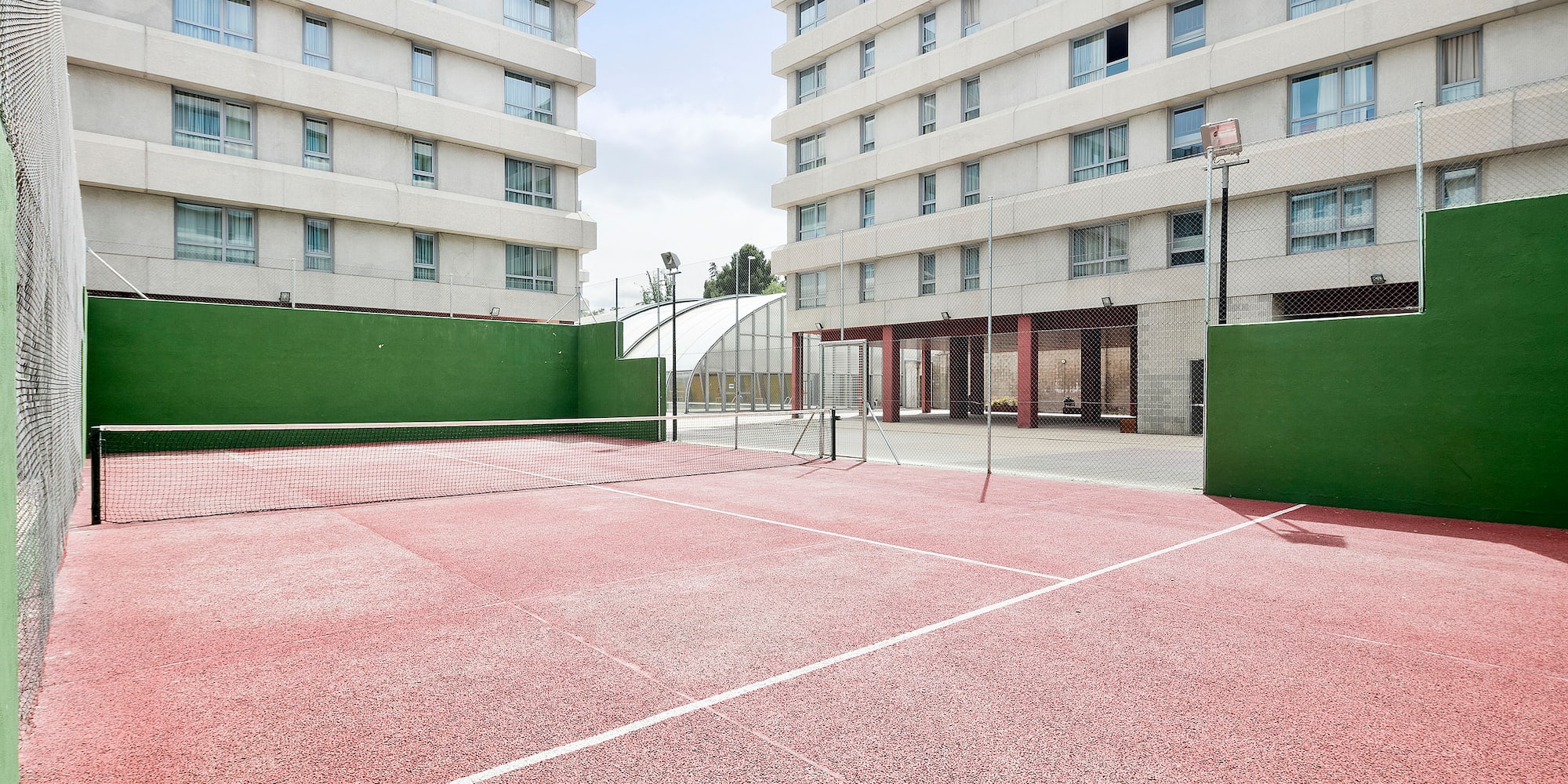 a tennis court with a net in front of a building