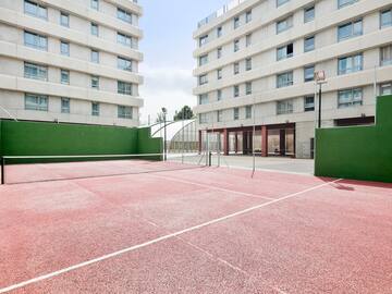 a tennis court with a net in front of a building