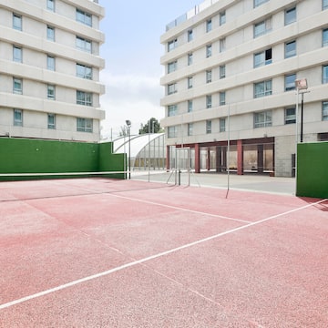 a tennis court with a net in front of a building