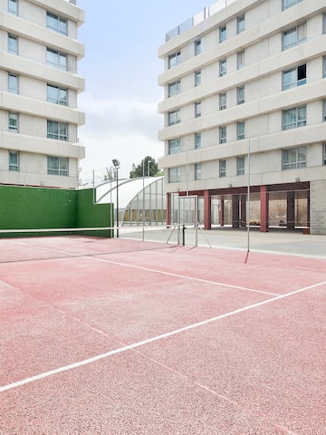 a tennis court with a net in front of a building