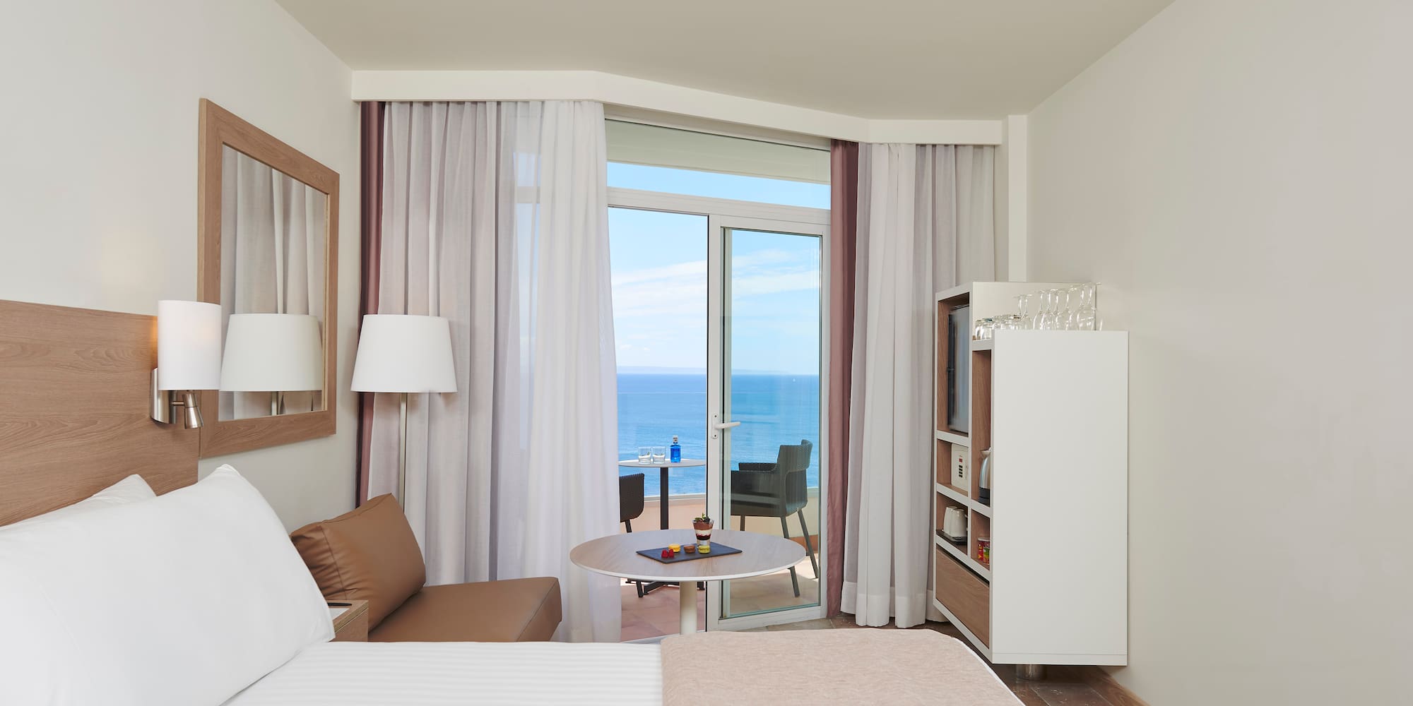 a room with a bed and a table and a glass door