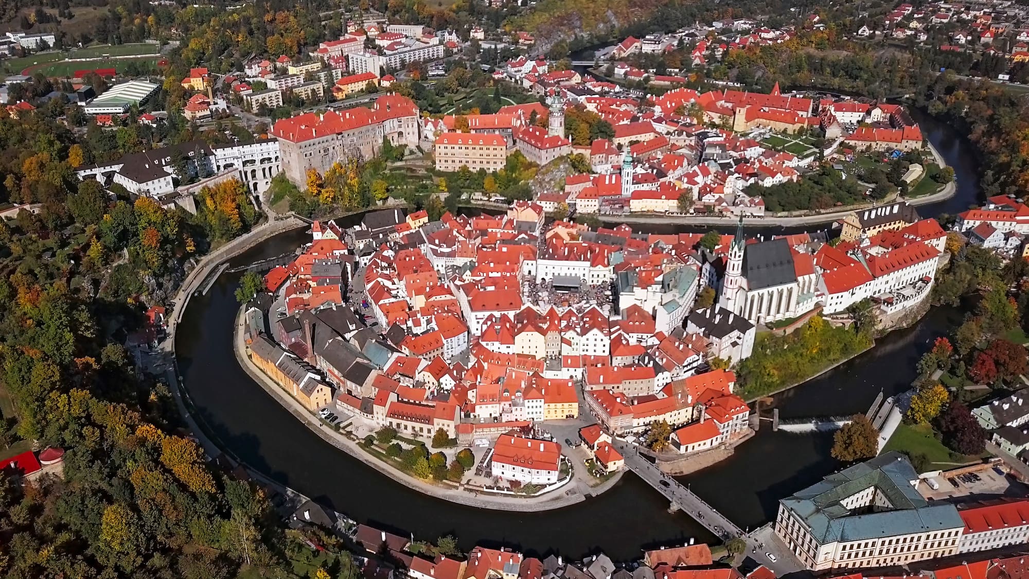 a city with red roofs and a river