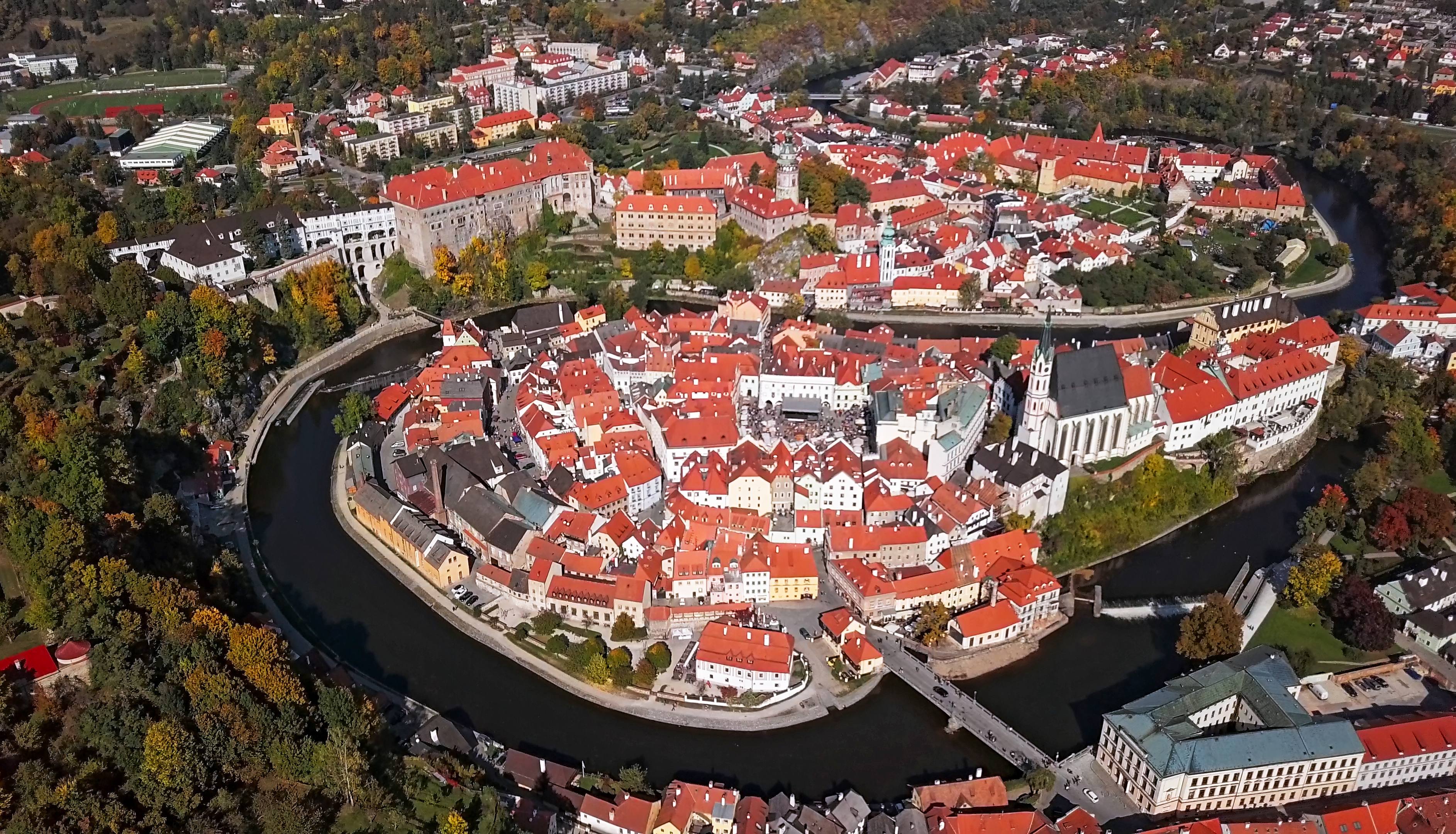 a city with red roofs and a river