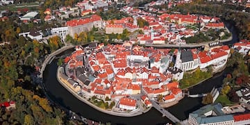 a city with red roofs and a river