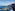 Rugged coastal cliffs and natural sea arch in deep blue ocean waves.
