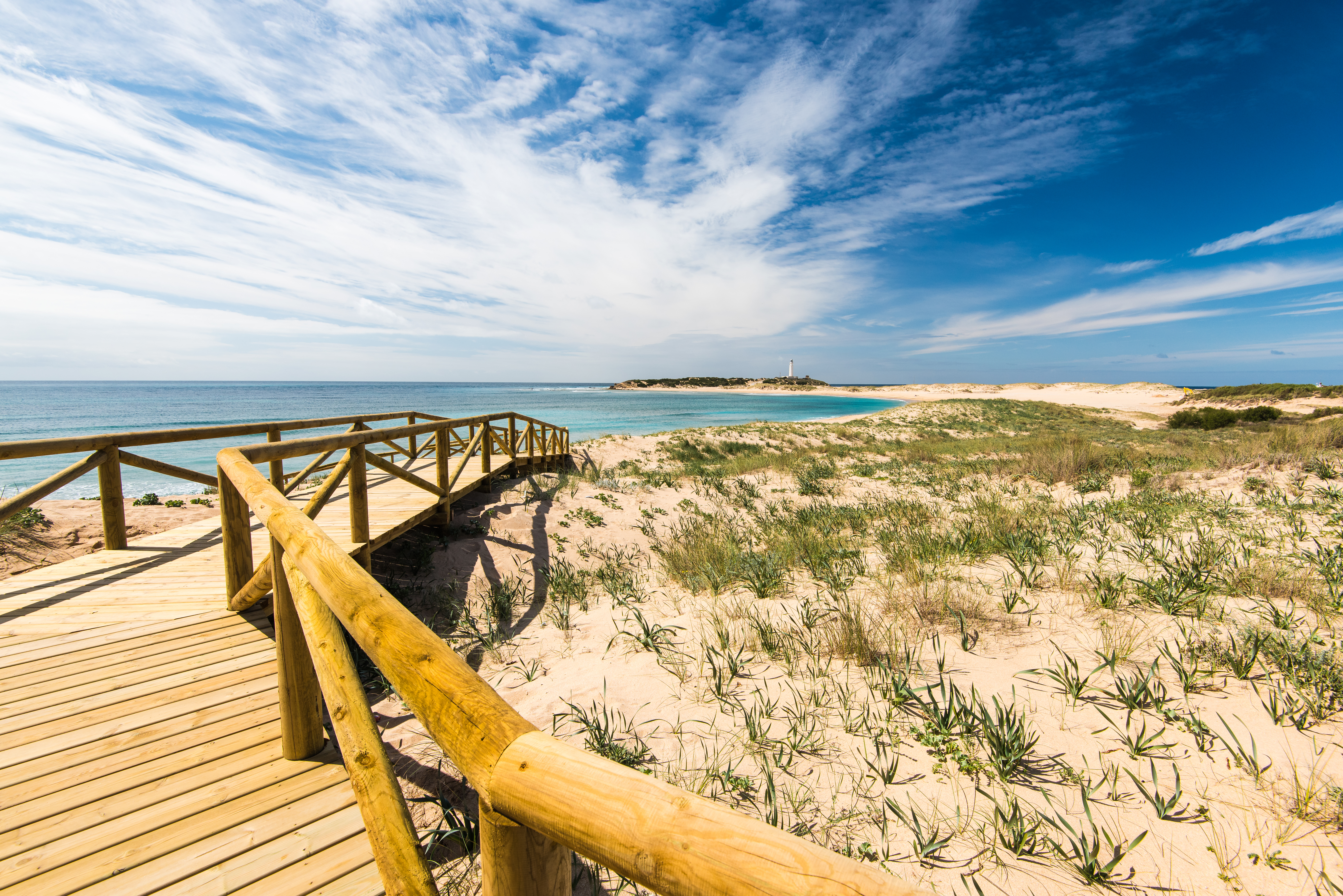 a wooden walkway leading to a beach