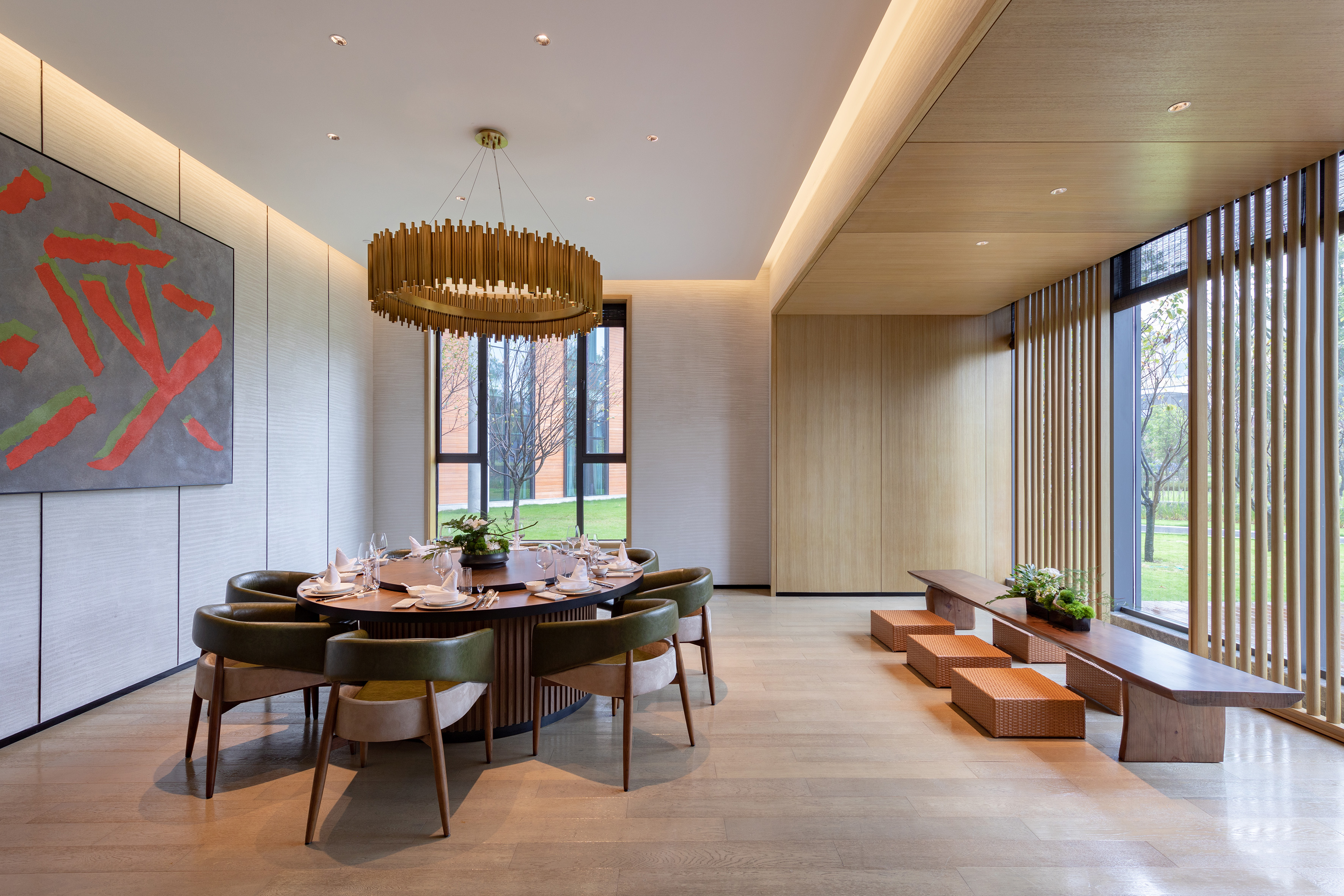 Modern dining room with round table, elegant chandelier, and wooden interior.