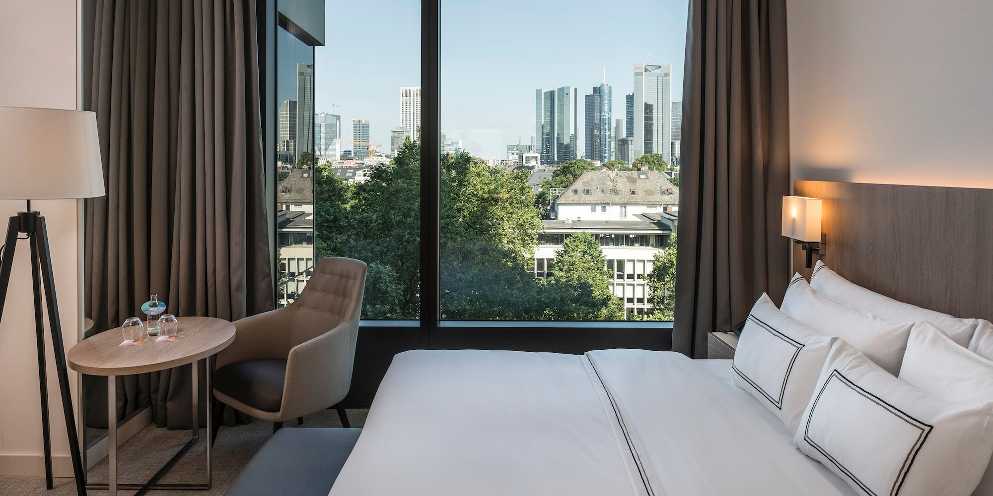 a hotel room with a large window and a city view