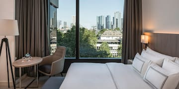 a hotel room with a large window and a city view