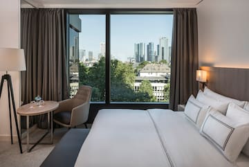 a hotel room with a large window and a city view