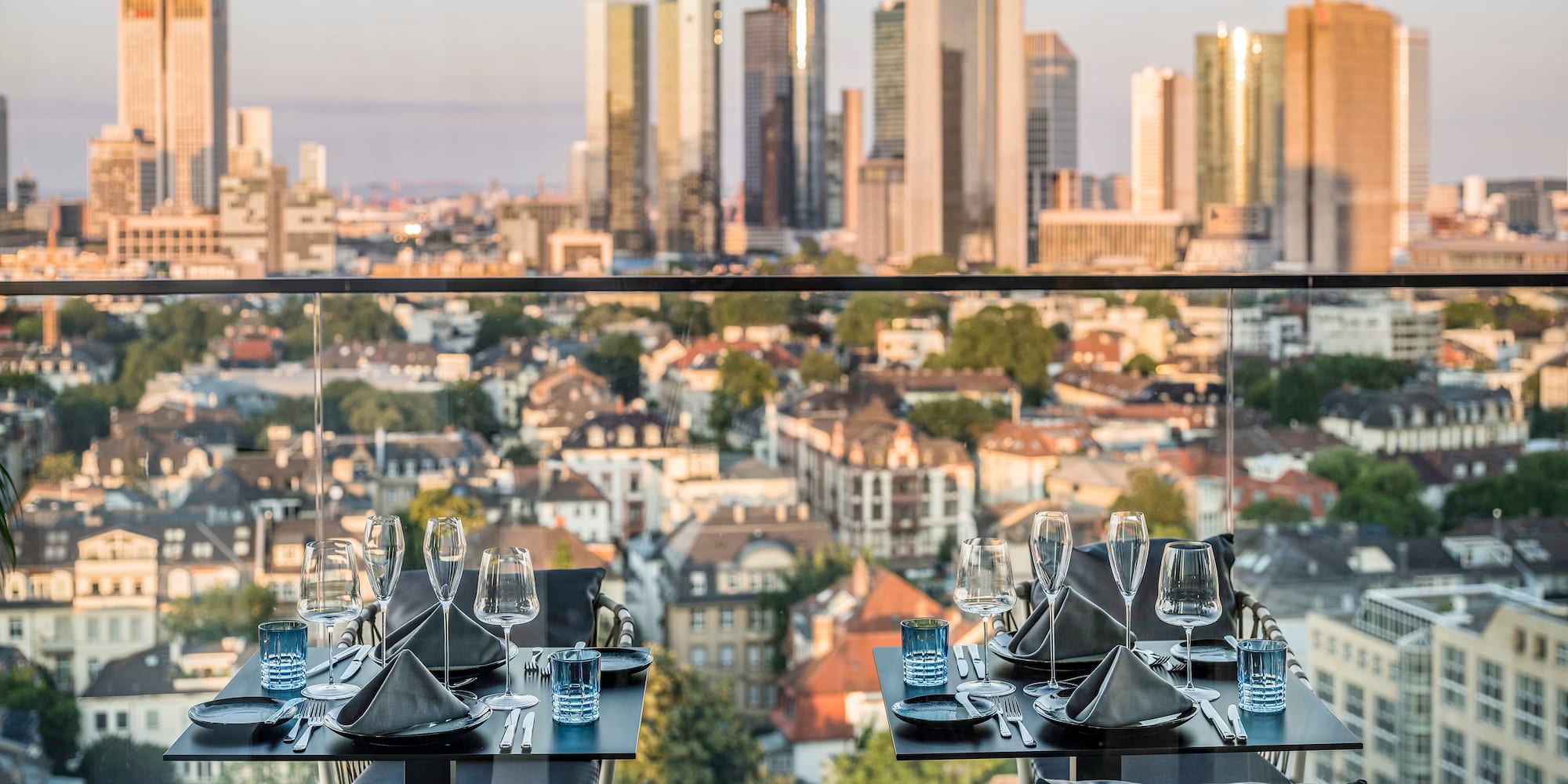 a table set for a dinner with a city in the background
