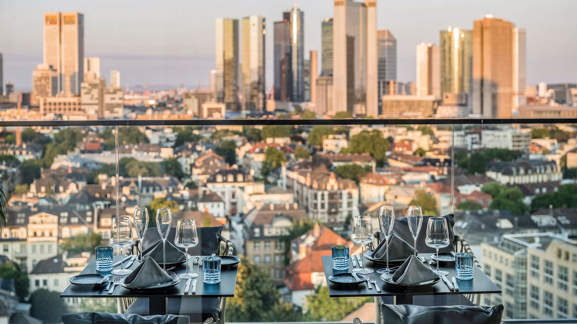 a table set for a dinner with a city in the background