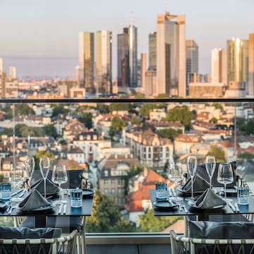 a table set for a dinner with a city in the background