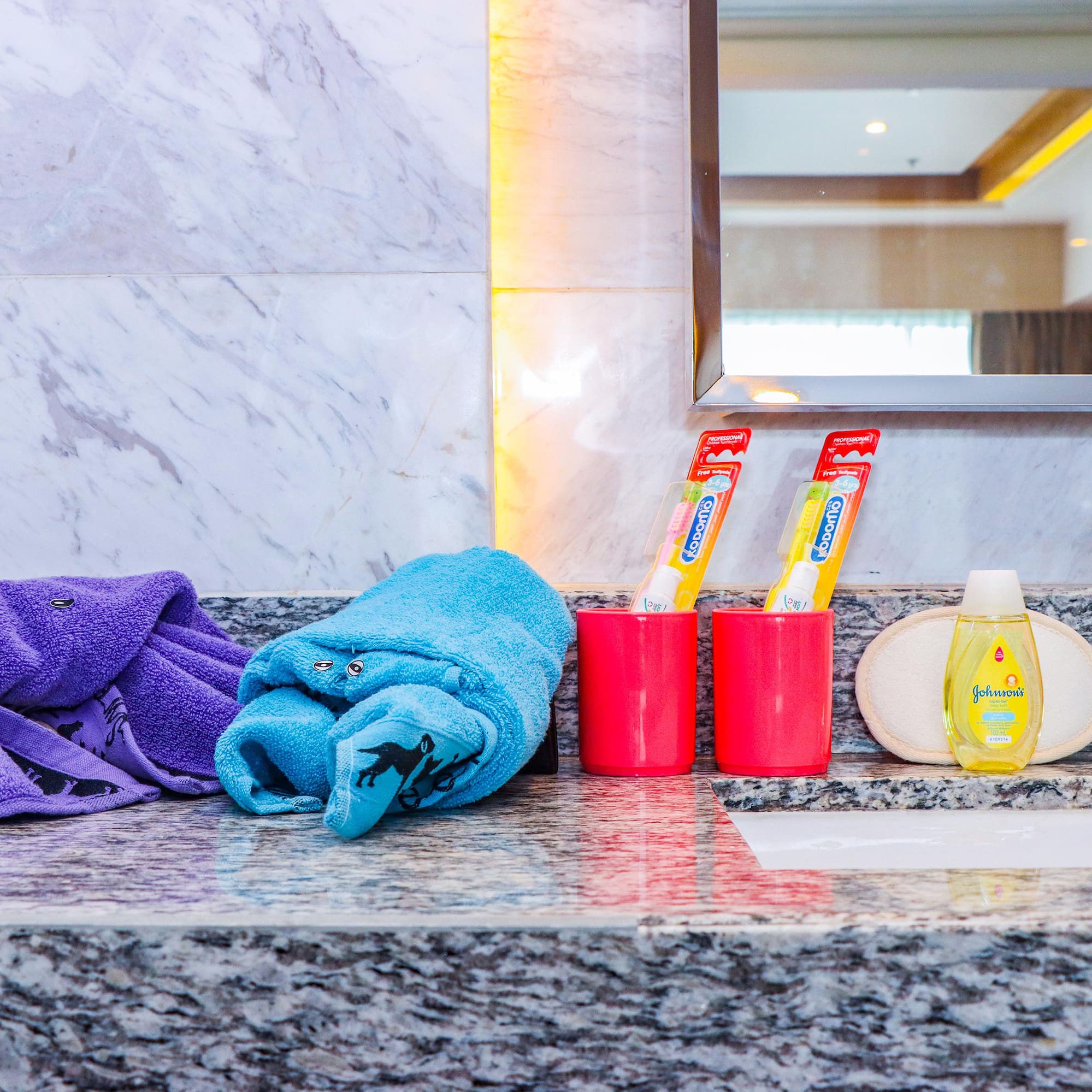 a bathroom sink with towels and toothpaste