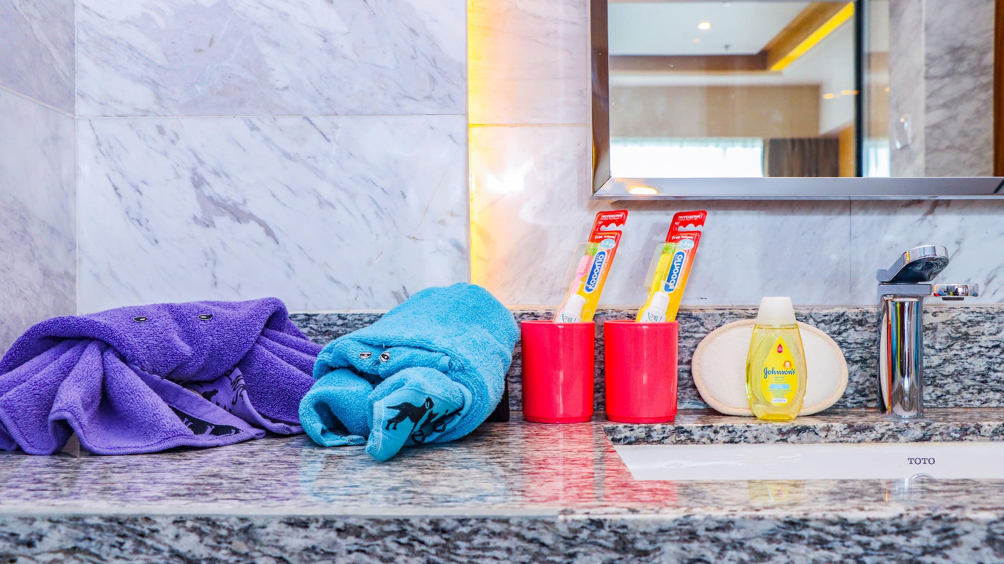 a bathroom sink with towels and toothpaste