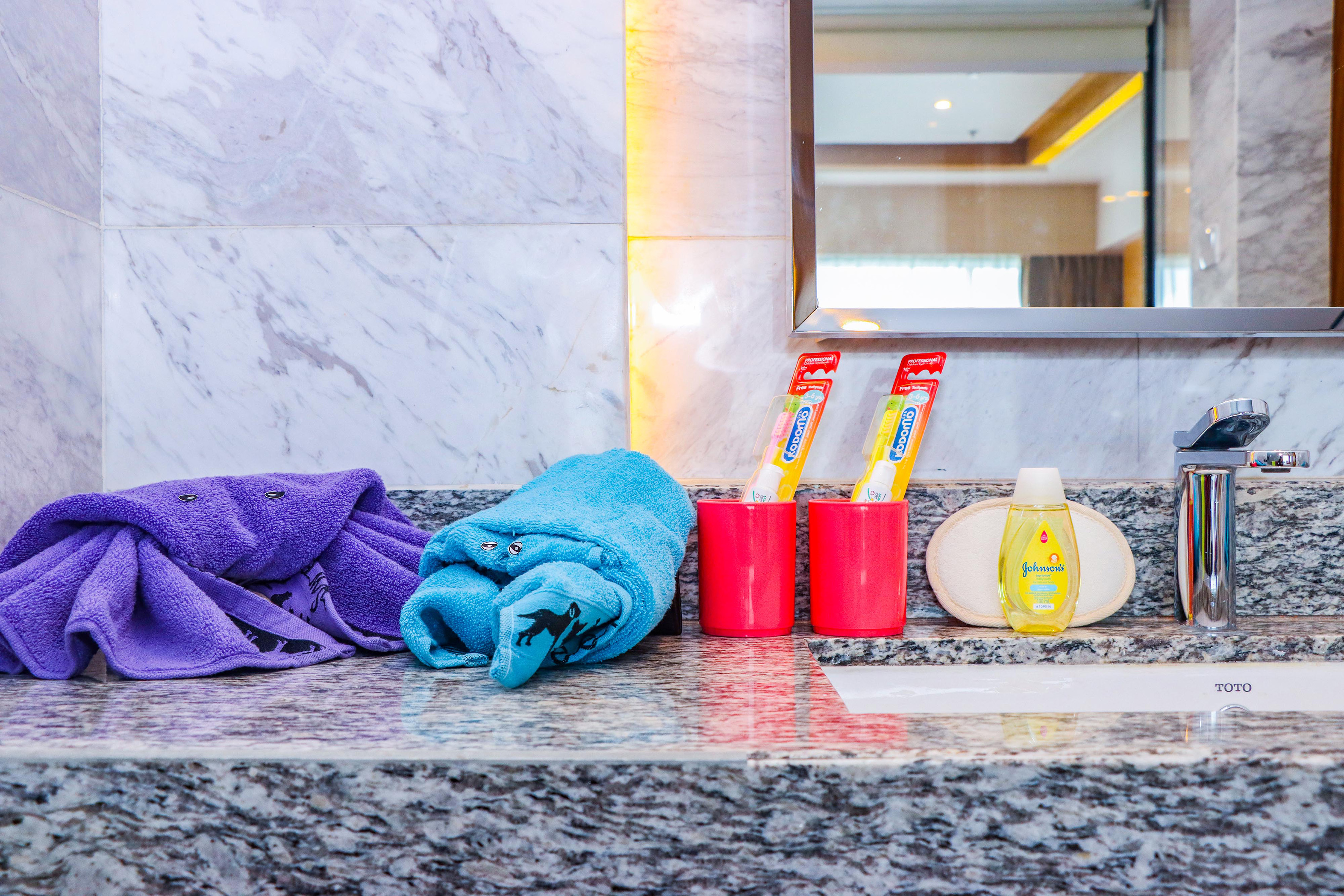 a bathroom sink with towels and toothpaste