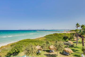 a beach with grass and trees and a body of water