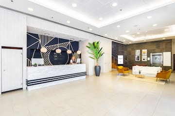 a lobby with a white and black reception desk and a plant