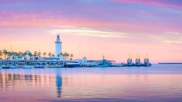 a body of water with boats and a lighthouse